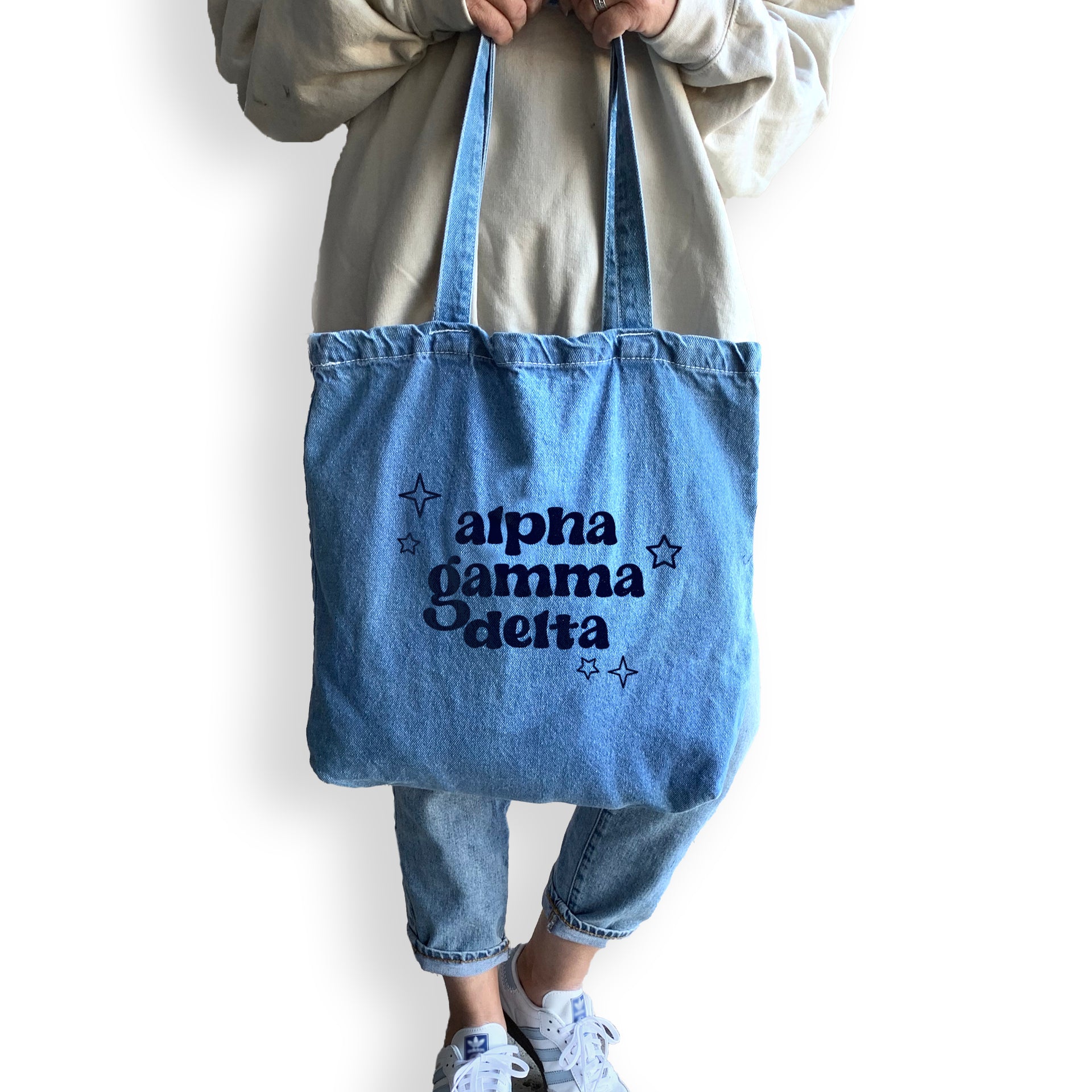 Alpha Gamma Delta denim blue tote bag shown on model