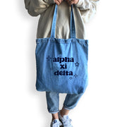 Alpha Xi Delta sorority denim blue tote bag carried by model, perfect for casual outings and everyday essentials