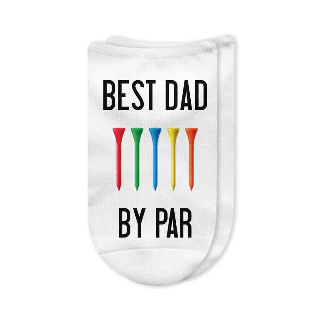 A pair of white no-show golf socks with the phrase "Best Dad By Par" printed on top, a perfect gift for golf-loving dads. Ideal for Father's Day, birthdays, or tournament prizes.