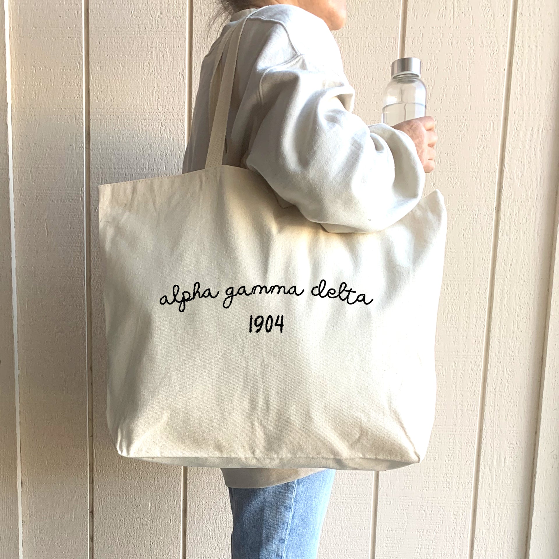 Alpha Gamma Delta – A young woman models a chic Alpha Gamma Delta tote bag, showcasing her sorority pride with a personalized design.