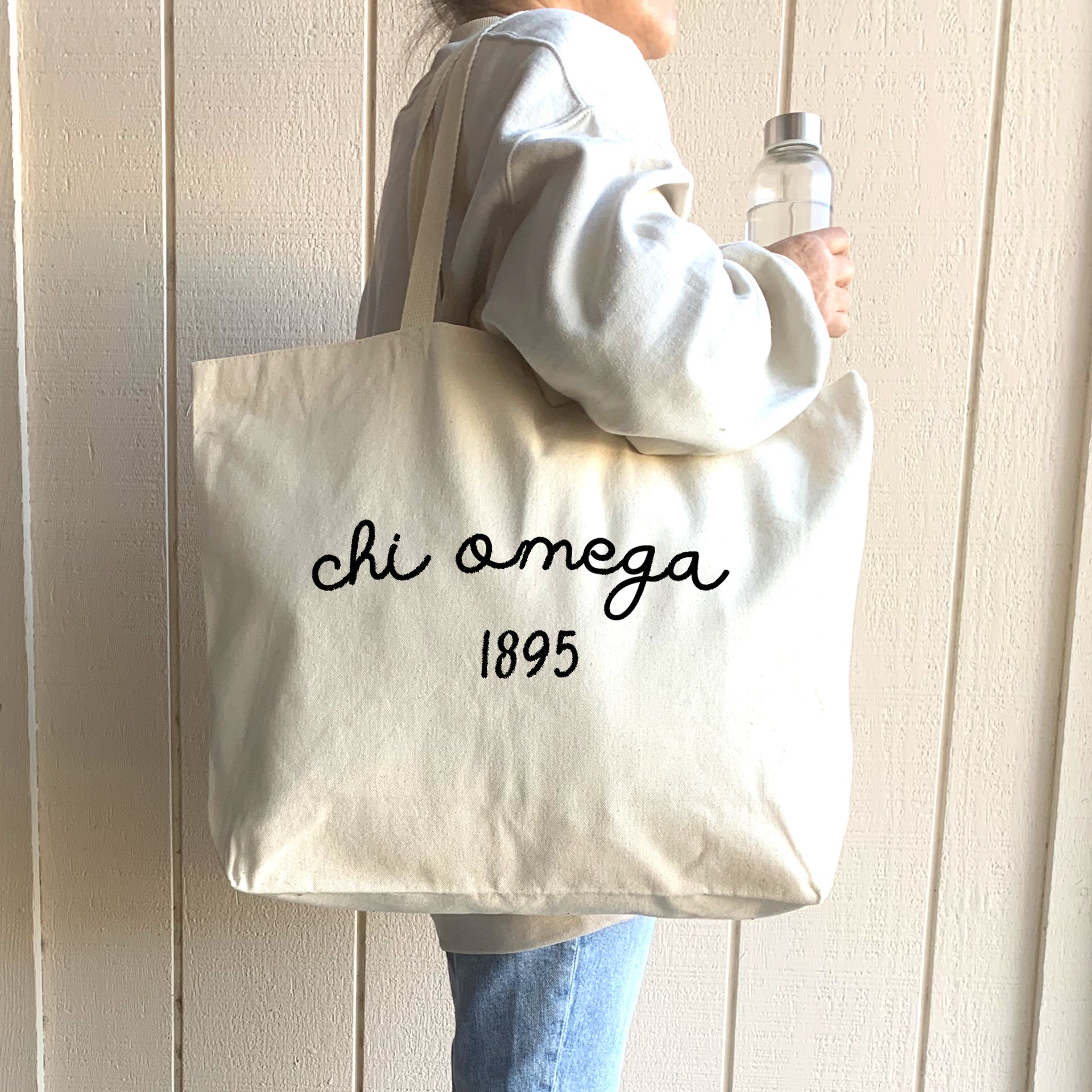 A college student carries a Chi Omega tote, designed for durability and style, making it an ideal companion for everyday activities.