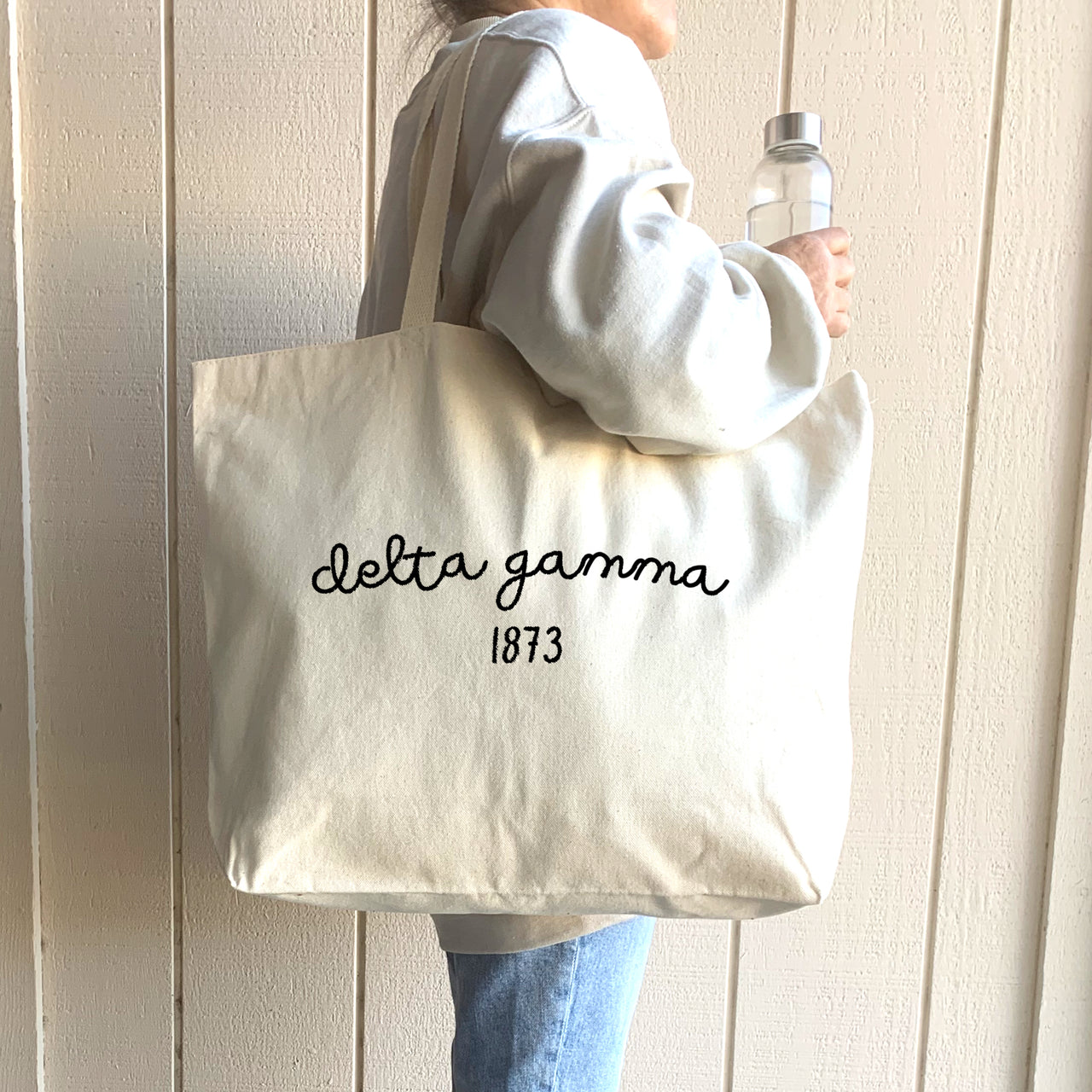 A stylish Delta Gamma sister models her tote bag, ideal for carrying books, sorority gear, or essentials for a weekend getaway.