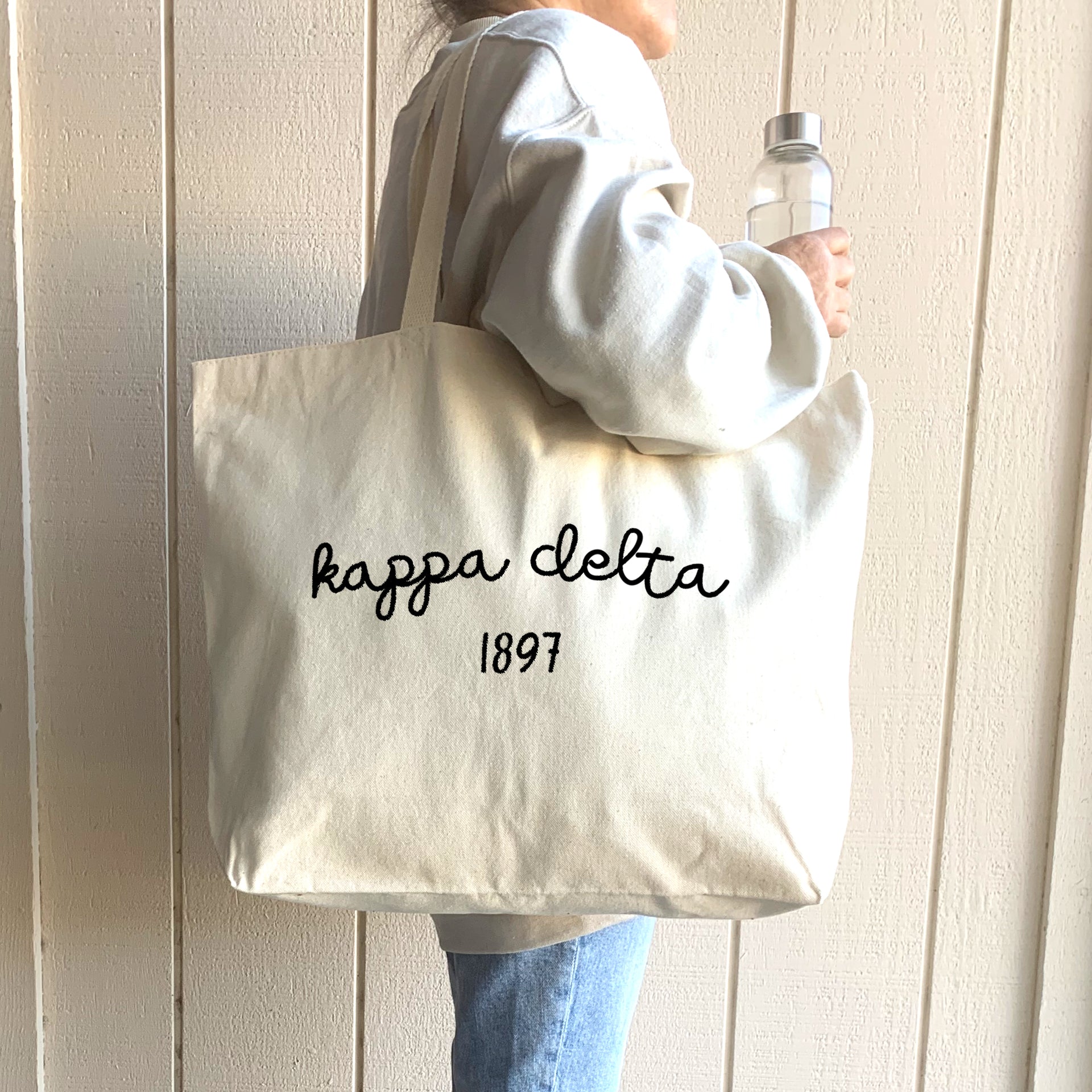 Kappa Delta – A cheerful Kappa Delta sister carries her tote bag on campus, highlighting the perfect blend of fashion and function.