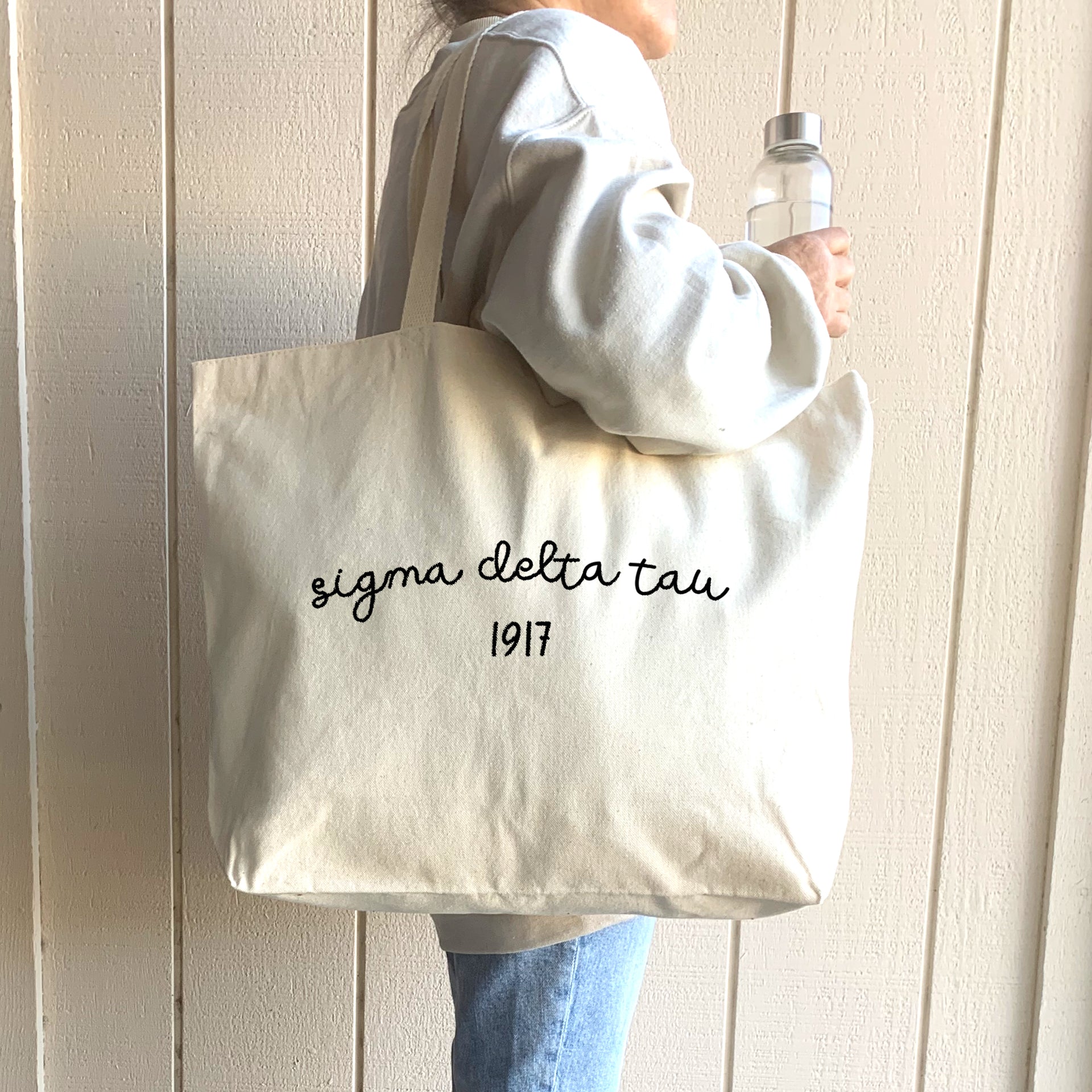 Sigma Delta Tau – A trendy sorority sister carries her Sigma Delta Tau tote bag, designed for comfort and convenience.