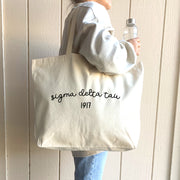 A young woman models her Sigma Delta Tau tote, designed for both comfort and convenience.