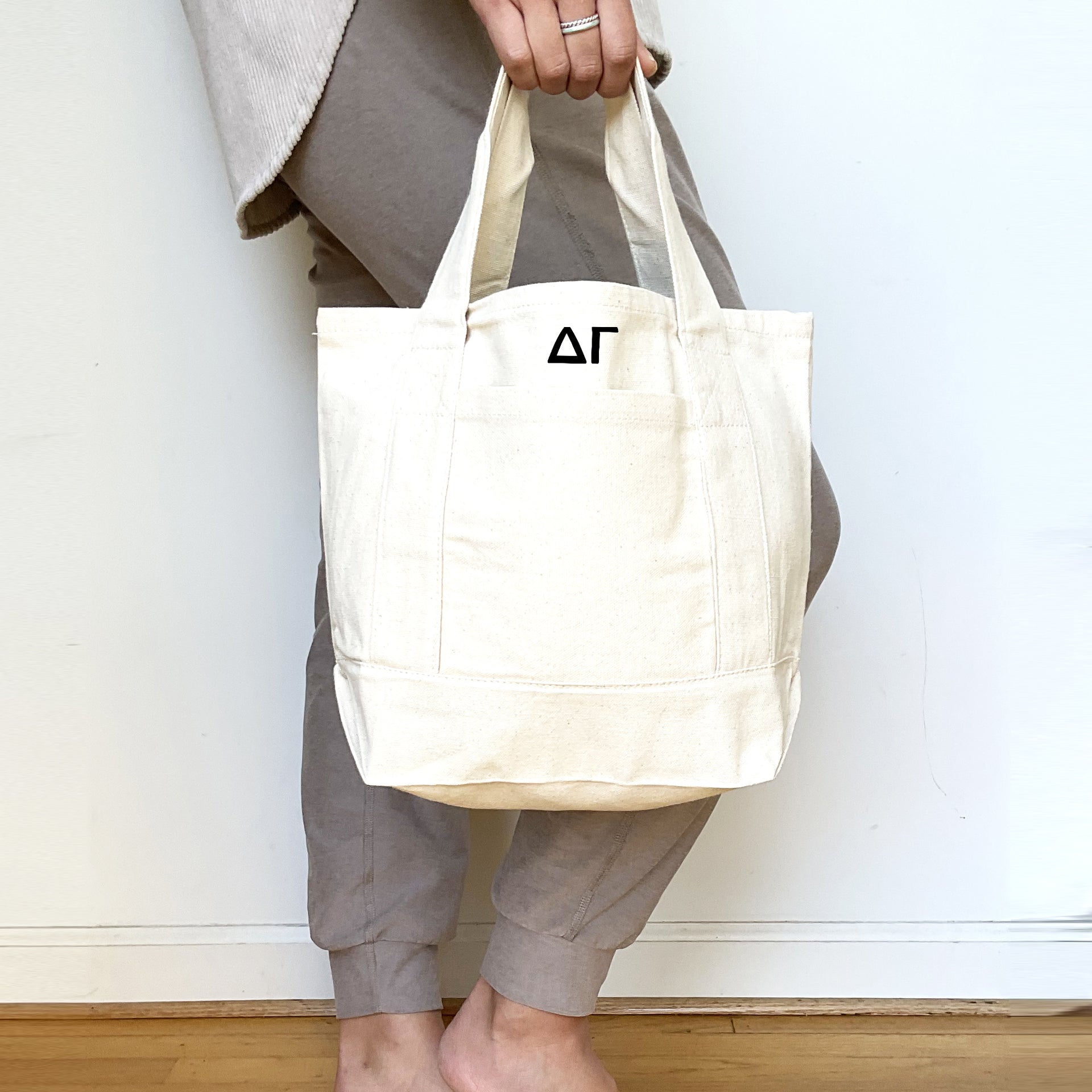 Delta Gamma Sorority Canvas Tote – A woman with a canvas tote displaying the Greek letters of Delta Gamma, perfect for sorority events or everyday errands.