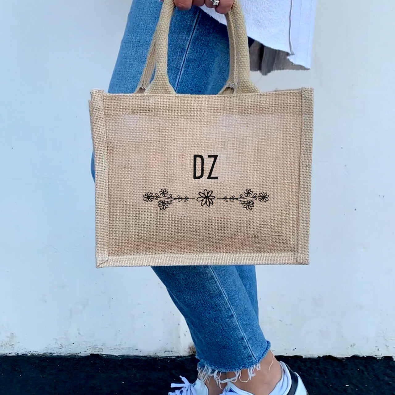 A model carrying the Delta Zeta floral burlap tote, perfect for showing off sorority pride in a chic and practical way.