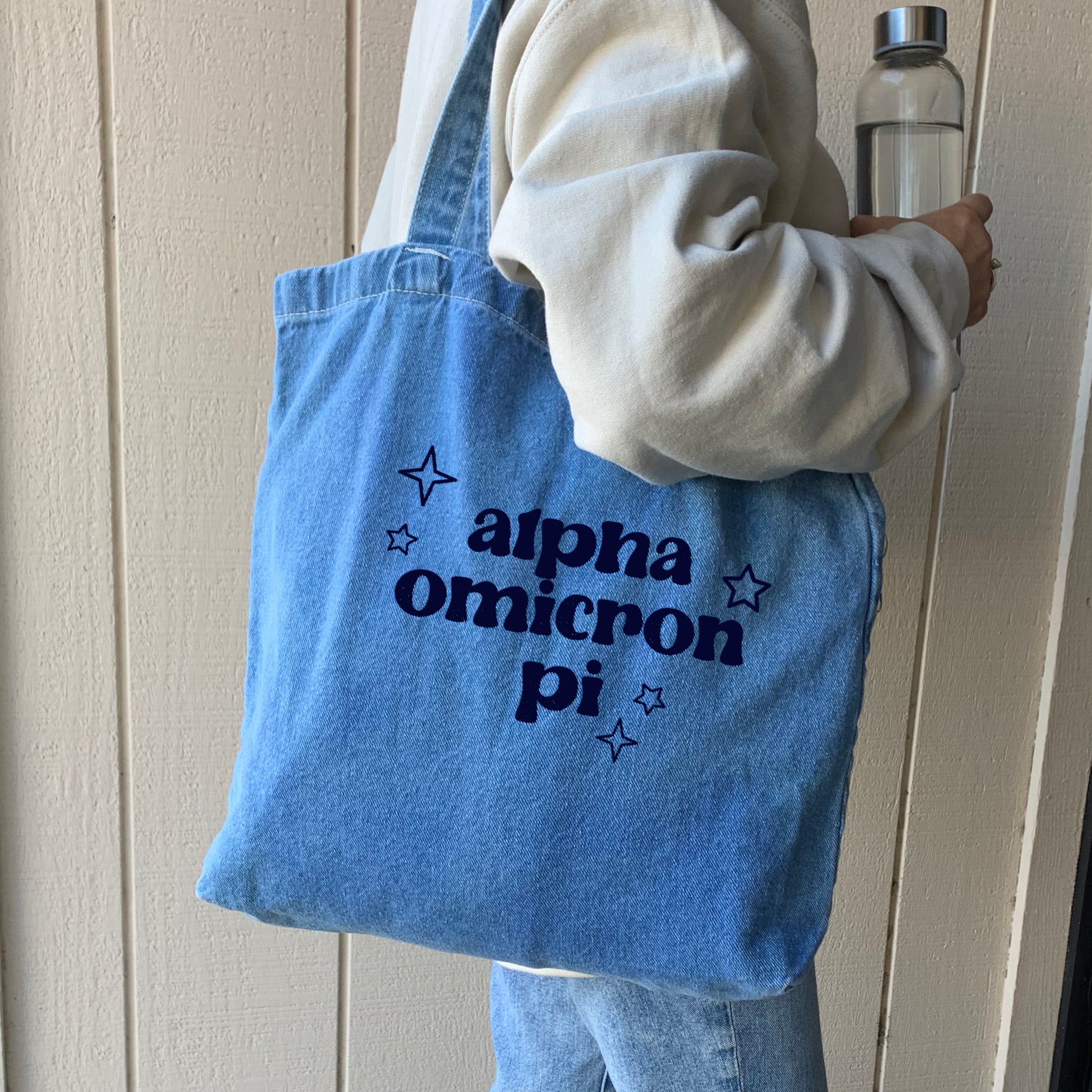 Alpha Omicron Pi sorority denim blue tote bag carried by model, perfect for casual outings and everyday essentials