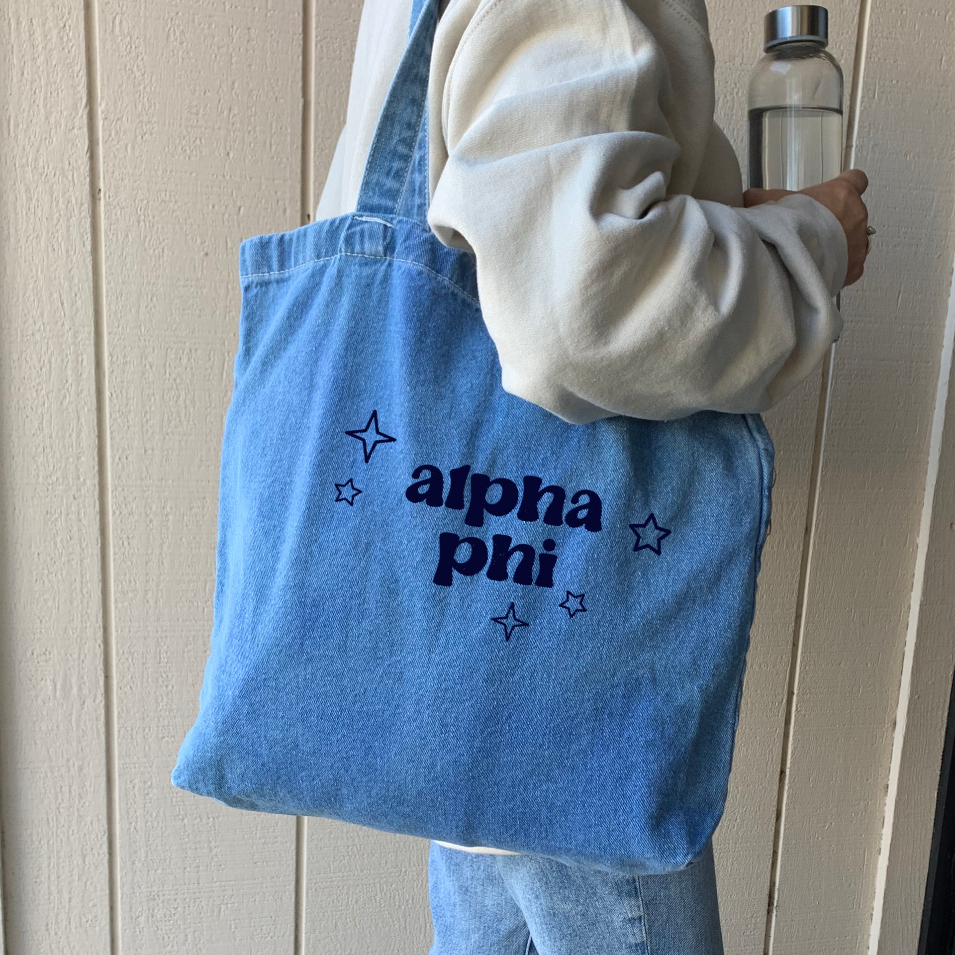 Alpha Phi denim blue tote bag shown on model