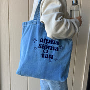 Alpha Omicron Pi denim blue tote bag shown on model