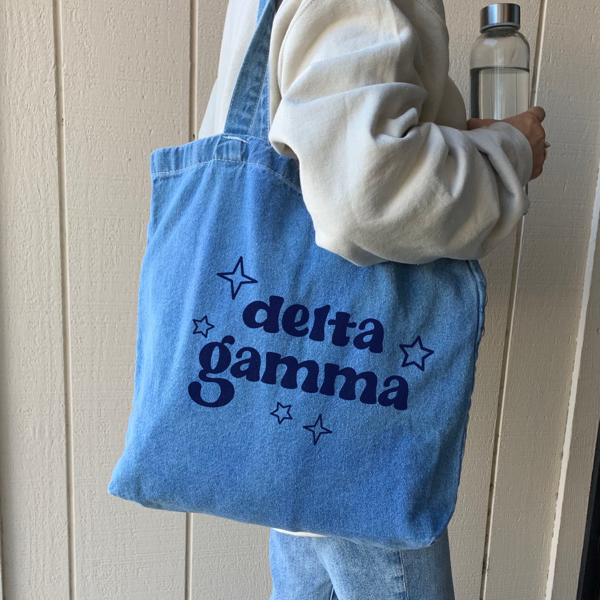 Delta Gamma sorority denim blue tote bag carried by model, perfect for casual outings and everyday essentials