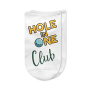 A pair of white no-show golf socks featuring the phrase "Hole in One Club" printed on top, designed for golfers celebrating their big achievement. A fun and memorable gift for men and women who have made a hole-in-one.