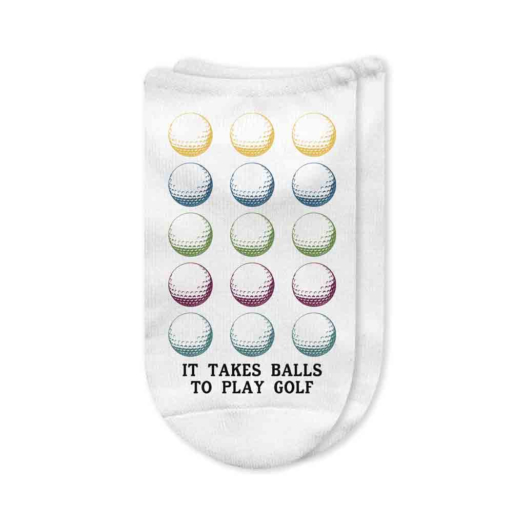 A pair of white no-show golf socks with the phrase "It Takes Balls to Golf" printed on top, featuring a playful and bold design. A fun gift for golfers who enjoy humor on and off the course.