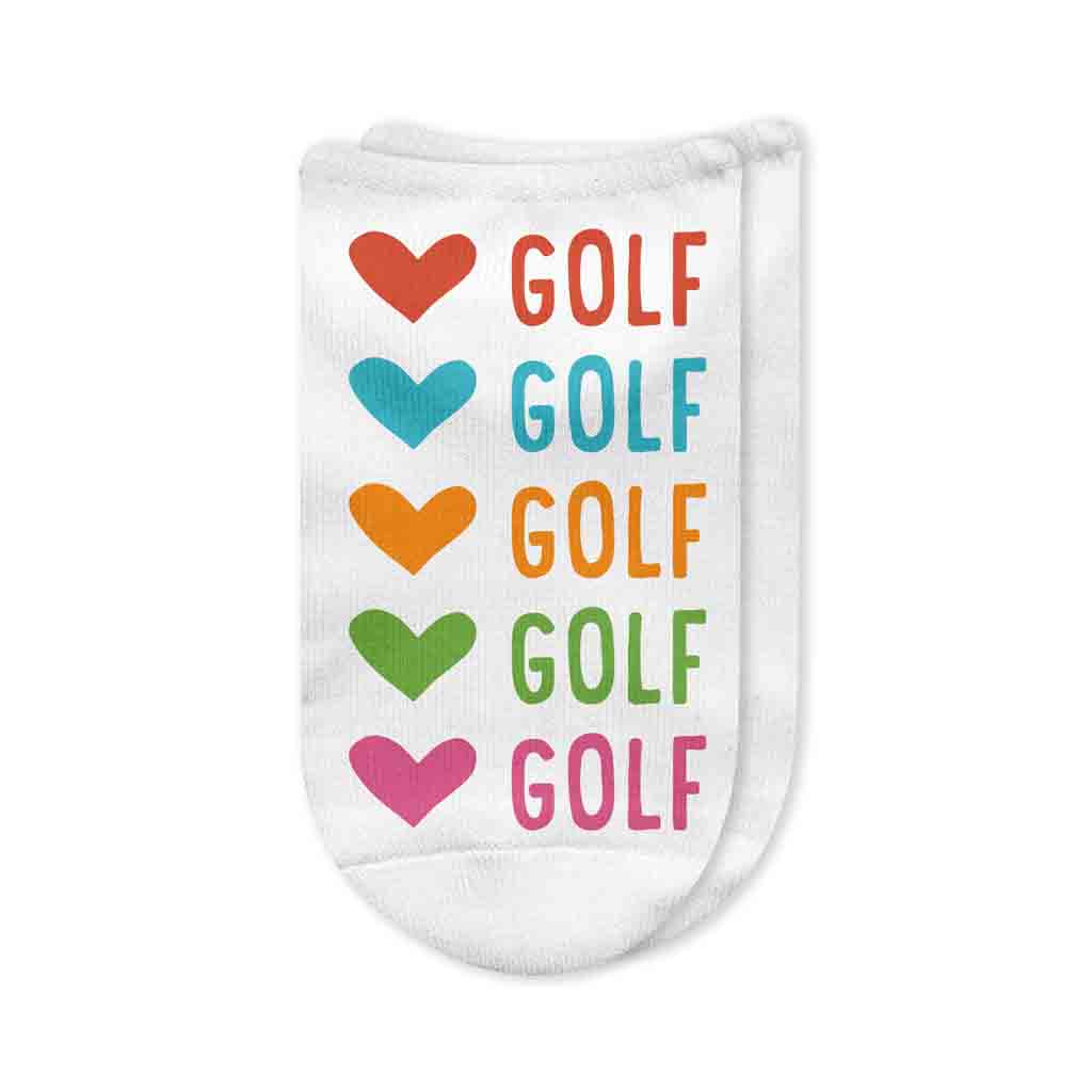 A pair of white no-show golf socks featuring the phrase "Love Golf" printed on top in pink and black lettering, accented with a heart and golf club design. A stylish and fun golf accessory for women.