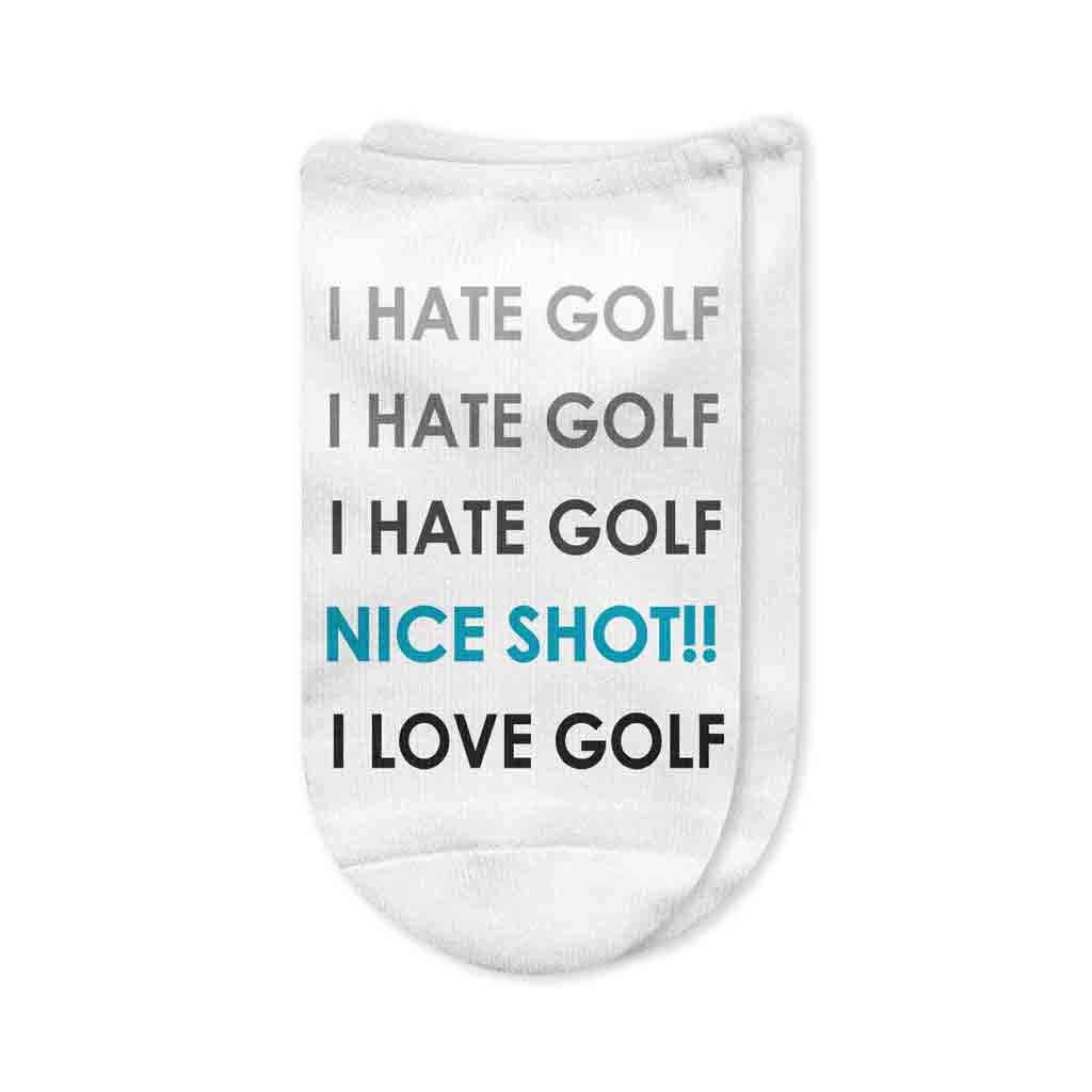 A white no-show golf sock featuring the humorous text "I HATE GOLF (NICE SHOT!!) I LOVE GOLF" printed on the top, showcasing a fun, custom design for golfers.