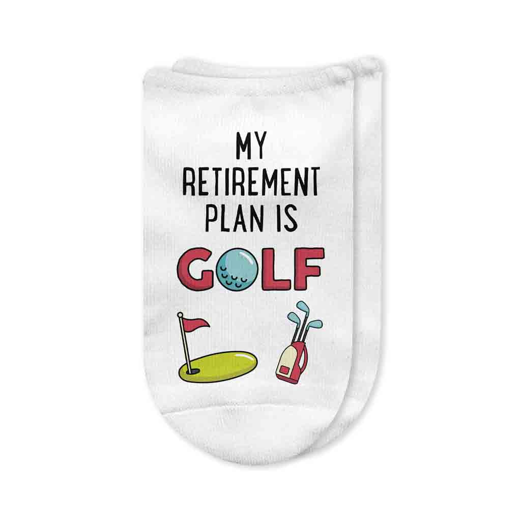 A pair of white no-show golf socks with the phrase "My Retirement Plan is Golf" printed on top, designed for retirees who love spending their time on the course. A fun and thoughtful gift for golf-loving retirees.